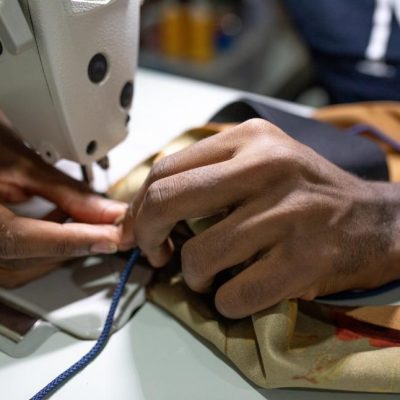 hands-working-on-sewing-machine